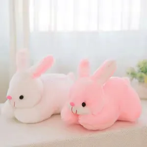 Close-up view of white and pink soft plush bunny toys with cute details on a windowsill.