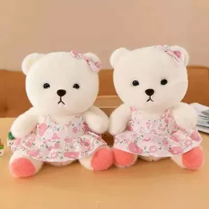 Paar süße weiße Teddybären in hübschen rosa Blumenkleidern mit passenden Haarschleifen