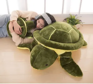 Large green sea turtle plush toy cushion shown with a model for size comparison