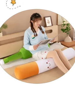 Young woman sitting on bed with creative cigarette and bottle shaped plush pillows