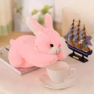 Detailed view of a soft pink plush bunny toy resting on a white table surface.