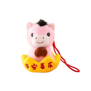 Pink plush horse mascot keychain sitting in a yellow gold ingot for Lunar New Year