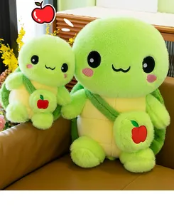 Detailed shot of two cute green turtle plush toys wearing small apple crossbody bags