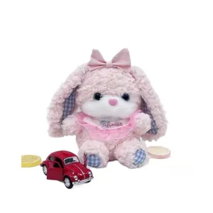 Detailed view of the pink puffy long-eared rabbit plush toy featuring a bow and bib.