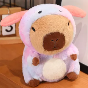 Cute capybara plush toy wearing a pink gradient costume on a wooden desk