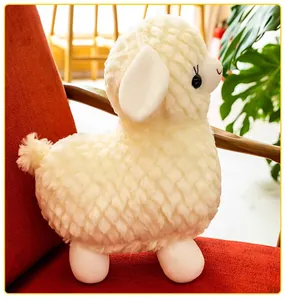 Dettaglio di un peluche di alpaca bianco con trama di pelliccia trapuntata su sedia rossa