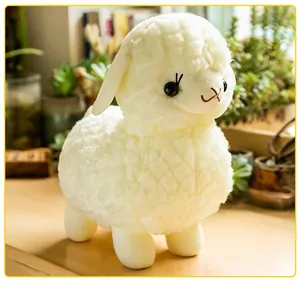 Primo piano di un morbido peluche di alpaca bianco con dettagli carini del viso