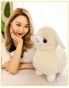 Vista dettagliata di un morbido peluche a forma di alpaca bianco con texture soffice