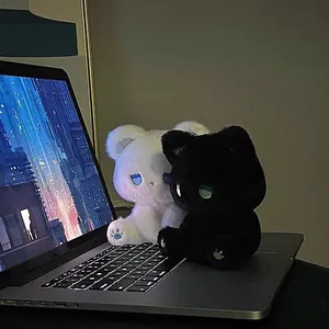 Detailansicht von süßen schwarz-weißen Emo-Plüschbären auf einer leuchtenden Tastatur