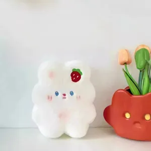 Close-up of fluffy white rabbit cookie plush toy with strawberry embroidery detail
