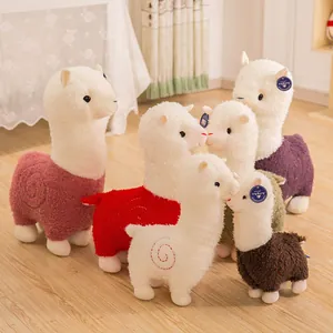 Kleurrijke alpaca knuffels met zachte krullende vacht in een gezellige warme kamer