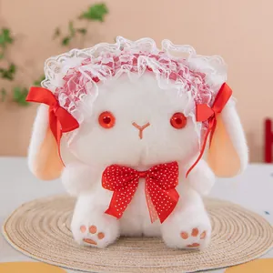 Macro view of cute white rabbit plush toy wearing a lace bonnet and red bow tie accessory