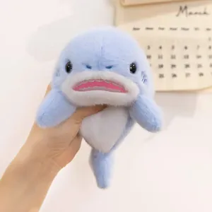 Hand-held close-up showing the soft plush texture of a cute 8-inch blue shark toy