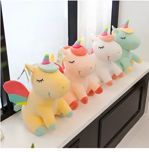 Vista detallada de peluches de unicornio arcoíris en varios colores sobre repisa