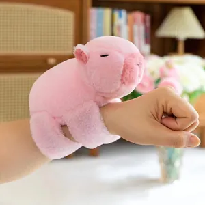 Detailansicht eines rosa Plüsch-Wasserschwein-Schnapparmbands am Handgelenk getragen