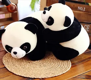 Two adorable panda plush toys sitting on a straw mat against a rustic wooden background.