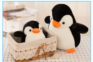 Süße schwarz-weiße Pinguin-Plüschtiere in einem dekorativen Spitzenkorb.