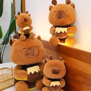 Close-up detail of four cute capybara plush toys wearing bee costumes with honey pots