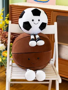 Cute soccer and basketball plush toys with smiling faces sitting on a white chair.