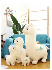 Group of cute white alpaca plush toys with rainbow hair displayed in a living room
