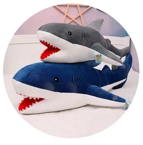 Detail view of two soft shark plush toys with sparkly starry sky fabric on a white bed