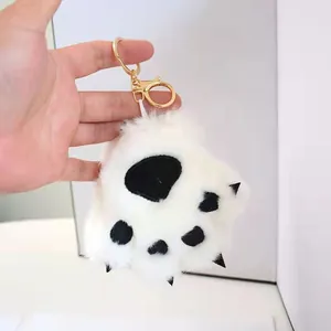 Detailed view of white plush animal paw keychain featuring soft fur and black claws