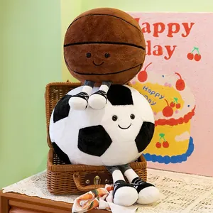 Plush basketball and soccer ball dolls with smiling faces in a gift basket