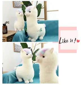 Detailed view of super cute white alpaca plush toys on a blue sofa