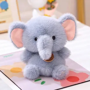 Close-up detail of a soft blue plush elephant toy with pink ears and LOVE embroidery