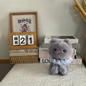 Detailed view of a soft grey plush cat toy with a delicate blue lace collar bib