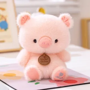 Close-up view of a cute pink pig plush toy featuring a decorative wooden neck tag and soft fur