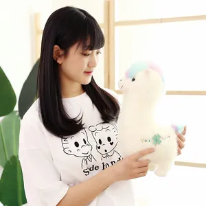 Cute white alpaca plush toy with rainbow hair held by a girl, perfect gift for kids