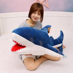Large blue starry shark plush toy with soft shimmering fabric held by a girl on bed