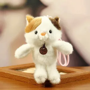 Detailed view of a soft and fluffy tricolor plush cat doll keychain with pink strap