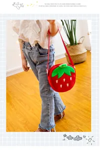 Detailansicht eines Kindes mit einer niedlichen Plüsch-Erdbeertasche im japanischen Stil