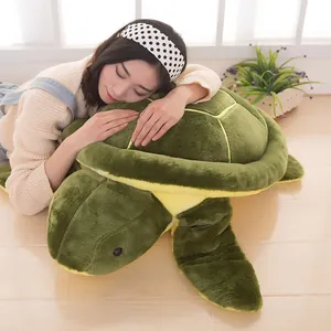 Giant green sea turtle plush toy being used as a cozy floor pillow by a model