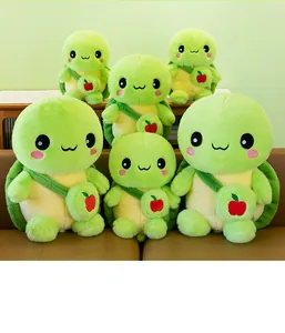 Detailed view of multiple cute green plush turtle dolls with red apple backpacks on sofa