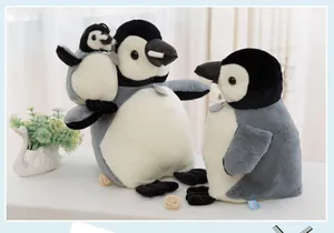 Three realistic baby penguin plush toys with soft gray fur displayed on a table