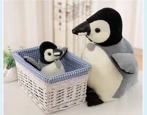 Close-up of lifelike plush penguins in a charming blue checkered woven basket