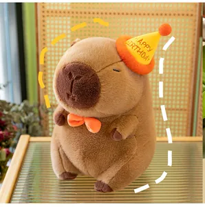 Detailed view of cute capybara plush toy with a yellow birthday hat and orange bowtie.