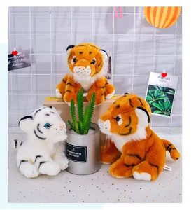 Close-up of realistic orange and white tiger plush toys in a cozy home setting.