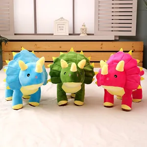Juego de tres peluches de dinosaurio triceratops de colores azul verde y rosa.
