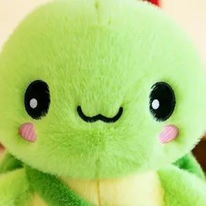 Cute green plush turtle toy with large eyes and backpack strap shown in close-up