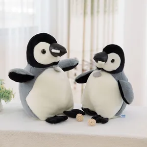 Pair of realistic penguin plush toys in large and small sizes on white surface