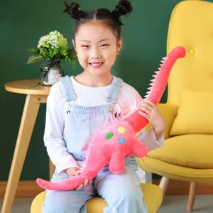 Adorable dinosaurio braquiosaurio de peluche rosa sostenido por una niña sonriente