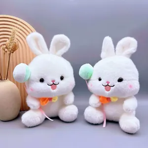 Close-up van twee schattige witte pluche konijnen die kleurrijke speelgoedballonnen vasthouden