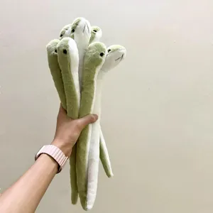 Un manojo de lindos peluches de serpiente verdes y blancos en la mano, muñeca suave