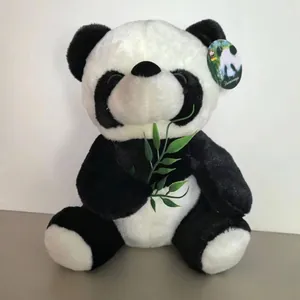 Detailed macro shot of a cute soft panda plush toy holding a small green bamboo branch