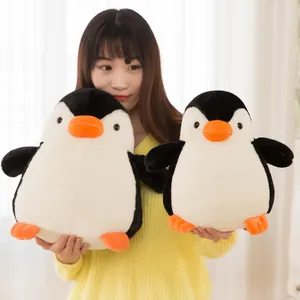 Zwei süße schwarz-weiße Pinguin-Plüschtiere in den Händen eines Modells als Geschenk