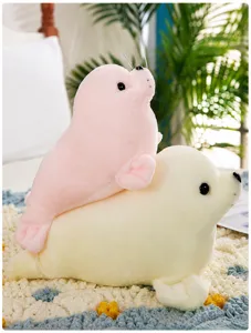 Close-up of cute pink and white seal plush toys stacked together in bedroom